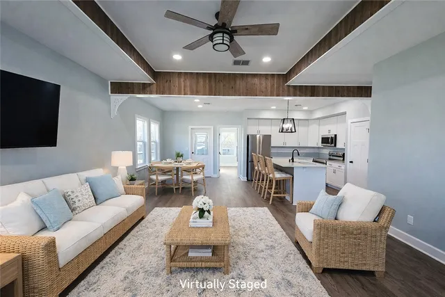a living room with furniture and kitchen view