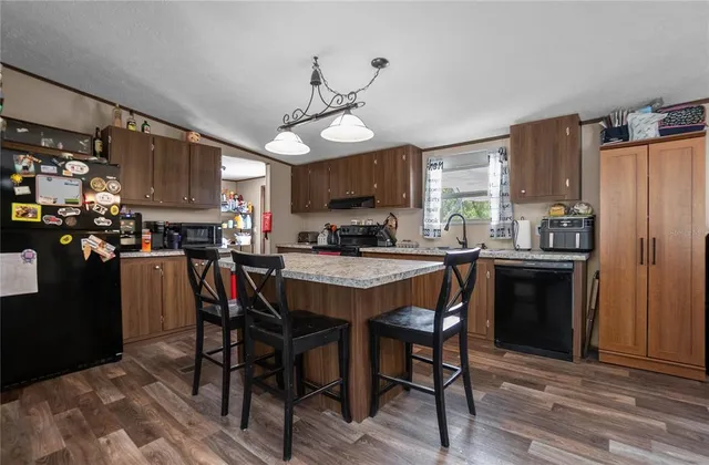 a kitchen that has a lot of cabinets in it and wooden floors