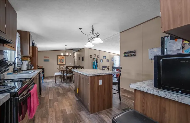 a kitchen with granite countertop a stove top oven sink and cabinets