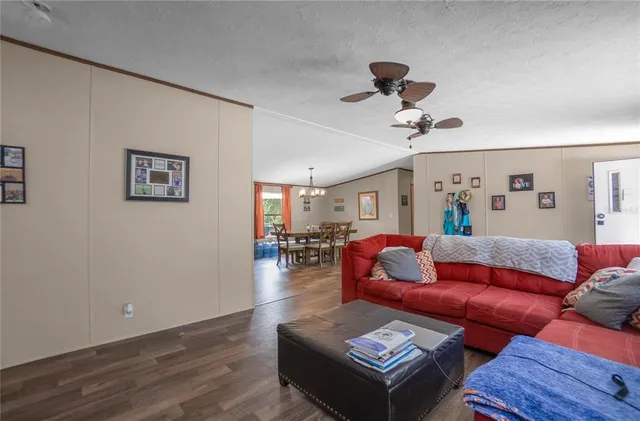 a living room with furniture a flat screen tv and a window
