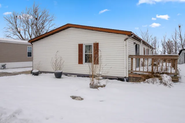 a backyard of a house with fire pit and chairs