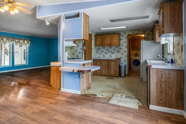 a view of a kitchen with kitchen island a counter top space and a wooden floor