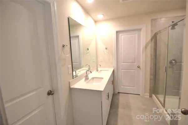 a bathroom with a sink mirror and shower