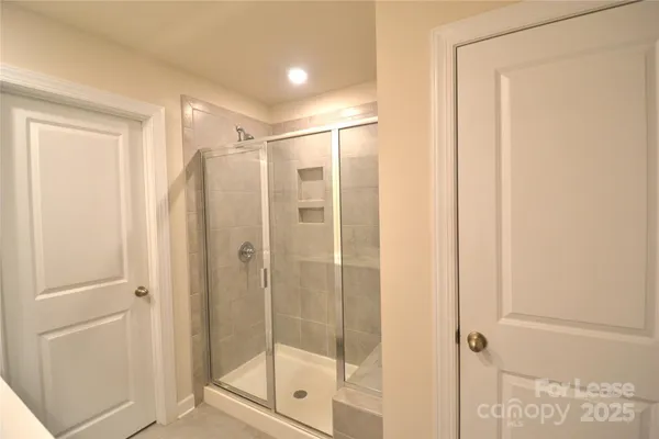 a bathroom with a shower and a glass door