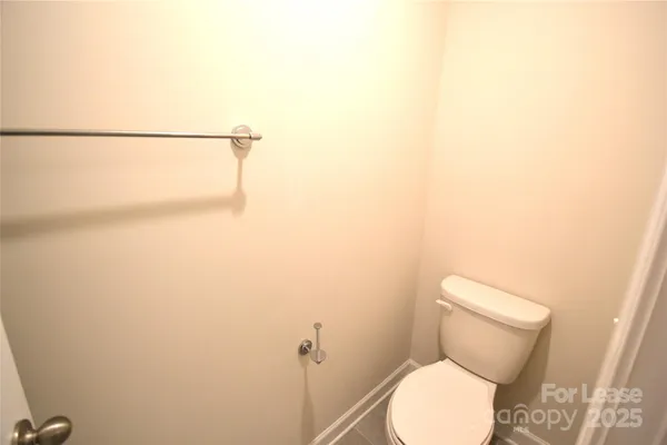 a white toilet sitting next to a white wall