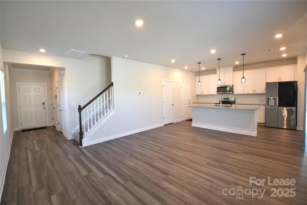 a view of kitchen with wooden floor and electronic appliances