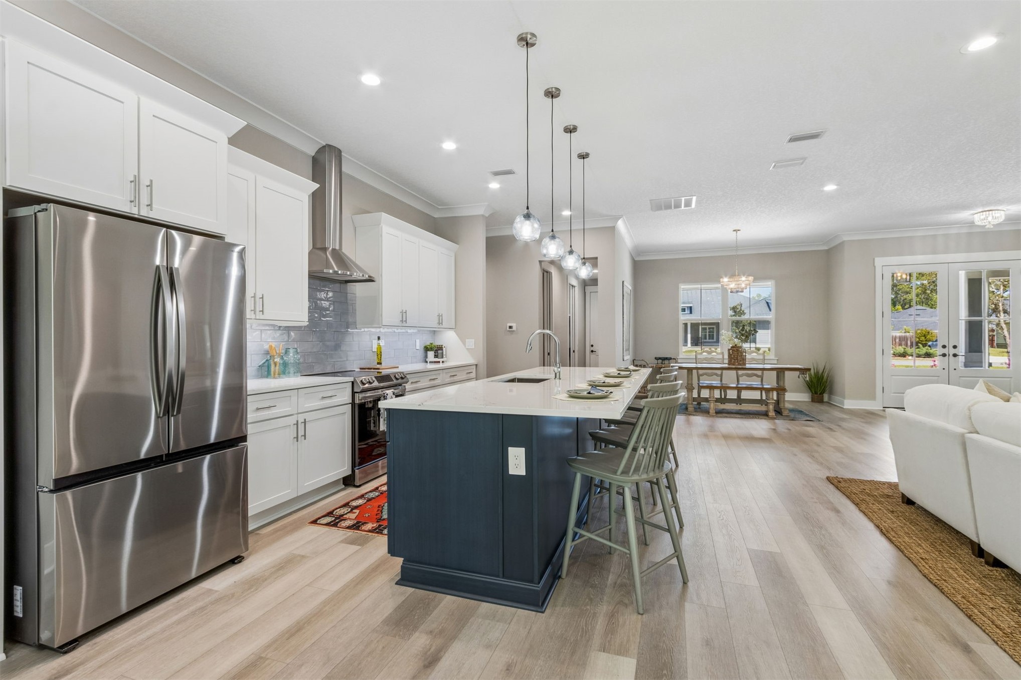 96050 Captains Pointe Road Yulee, FL 32097 - Photo 12 of 36 a kitchen with stainless steel appliances a dining table chairs stove refrigerator and cabinets