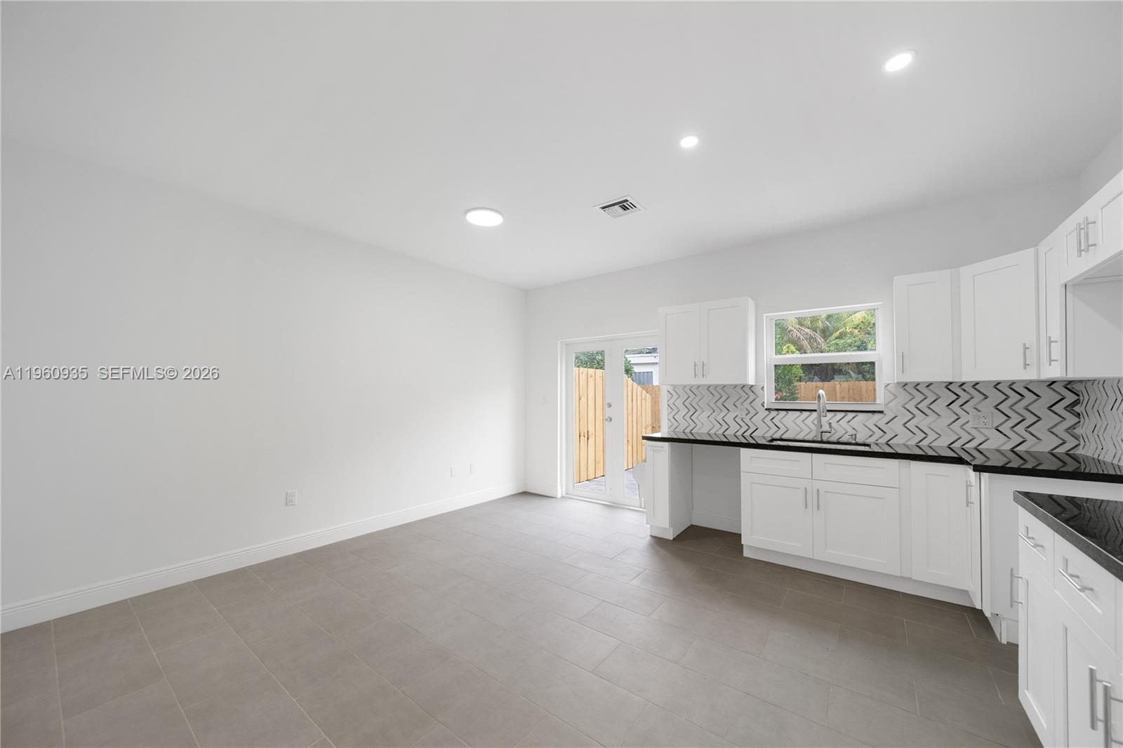 529 Northwest 56th Street Miami, FL 33127 - Photo 28 of 66 a kitchen with granite countertop a sink and a stove top oven