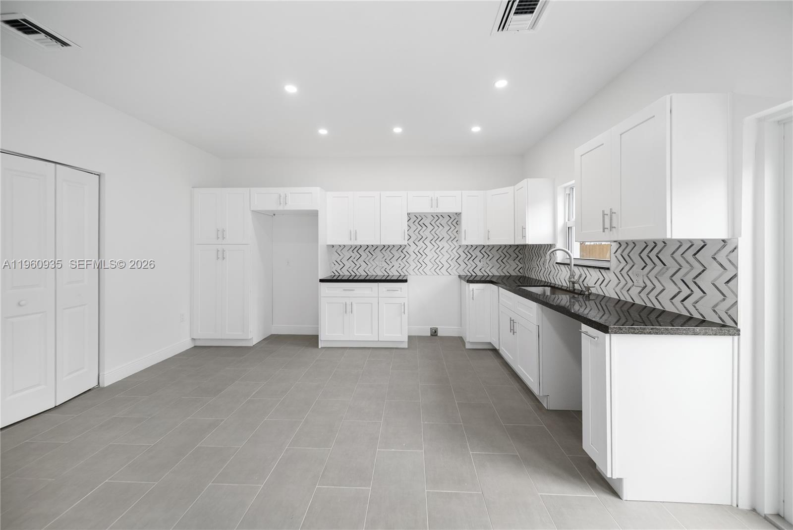 529 Northwest 56th Street Miami, FL 33127 - Photo 30 of 66 a kitchen with granite countertop white cabinets and refrigerator