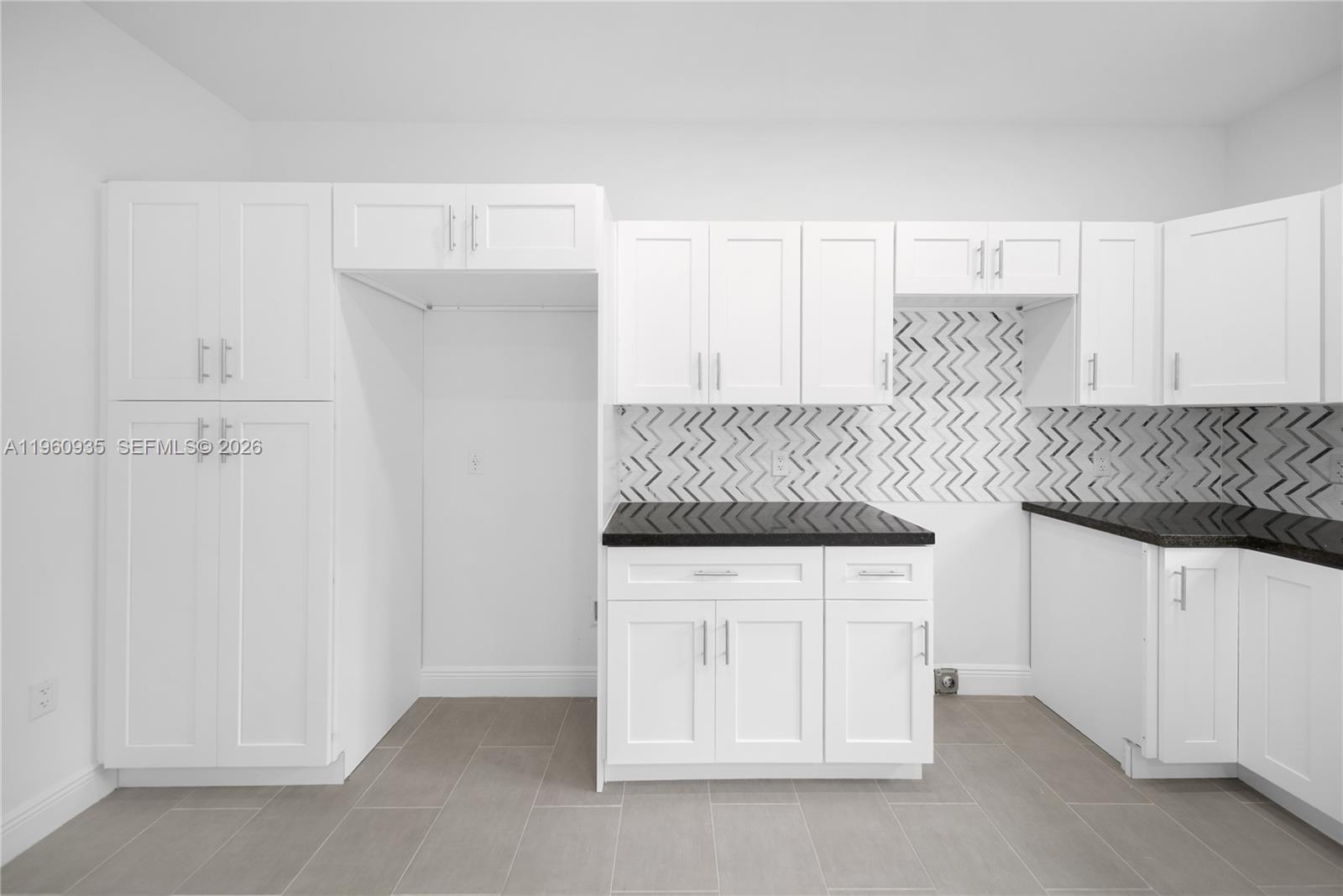 529 Northwest 56th Street Miami, FL 33127 - Photo 34 of 66 a kitchen with granite countertop white cabinets and white appliances