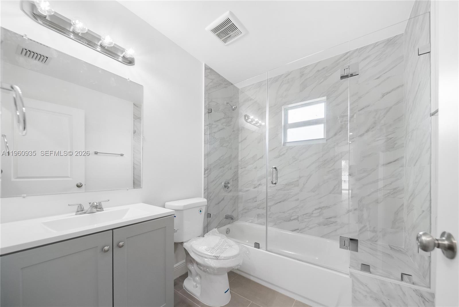 529 Northwest 56th Street Miami, FL 33127 - Photo 58 of 66 a bathroom with a bathtub shower sink mirror and toilet