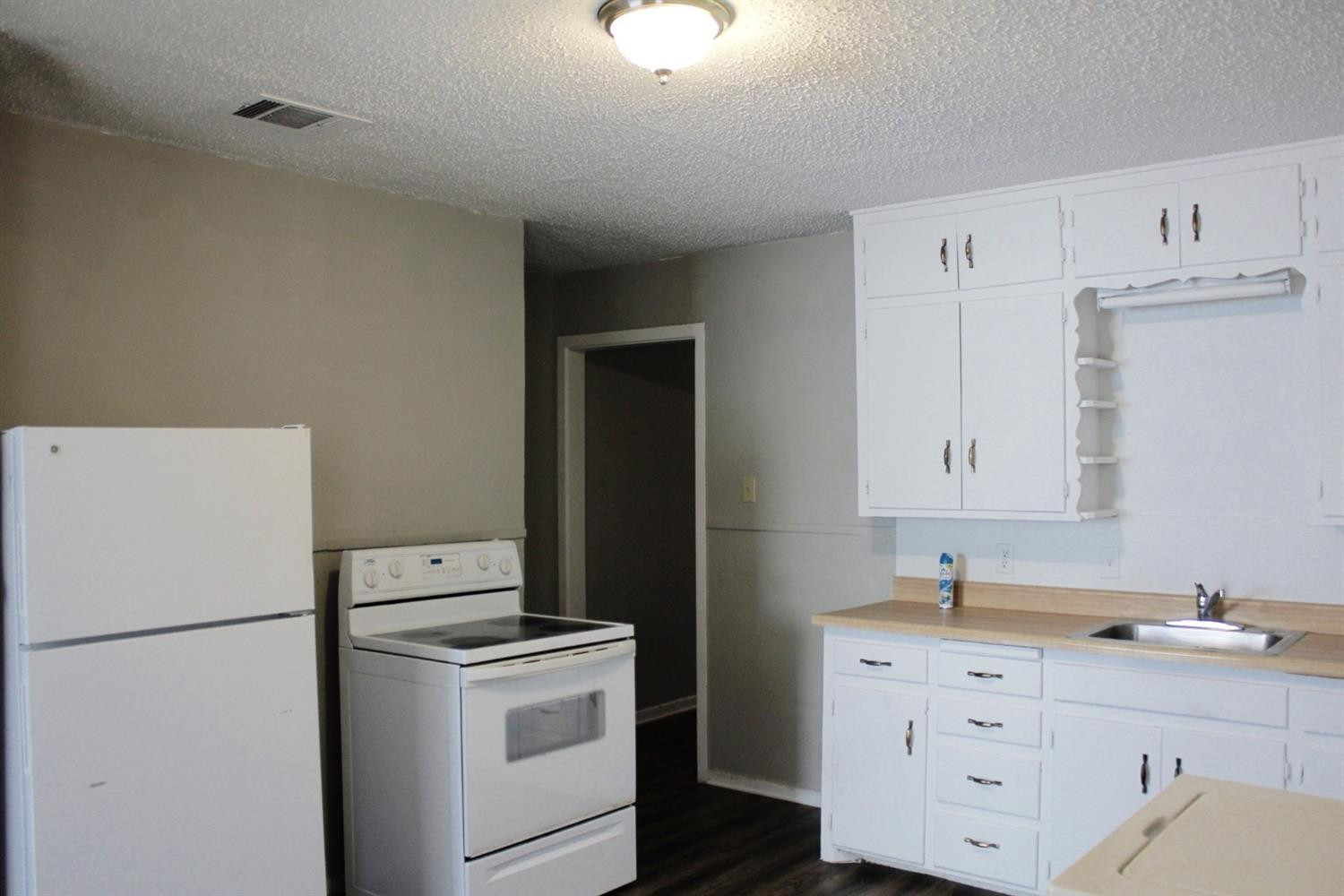 4424 36th Street, Unit A Lubbock, TX 79414 - Photo 2 of 6 a kitchen with cabinets appliances and wooden floor