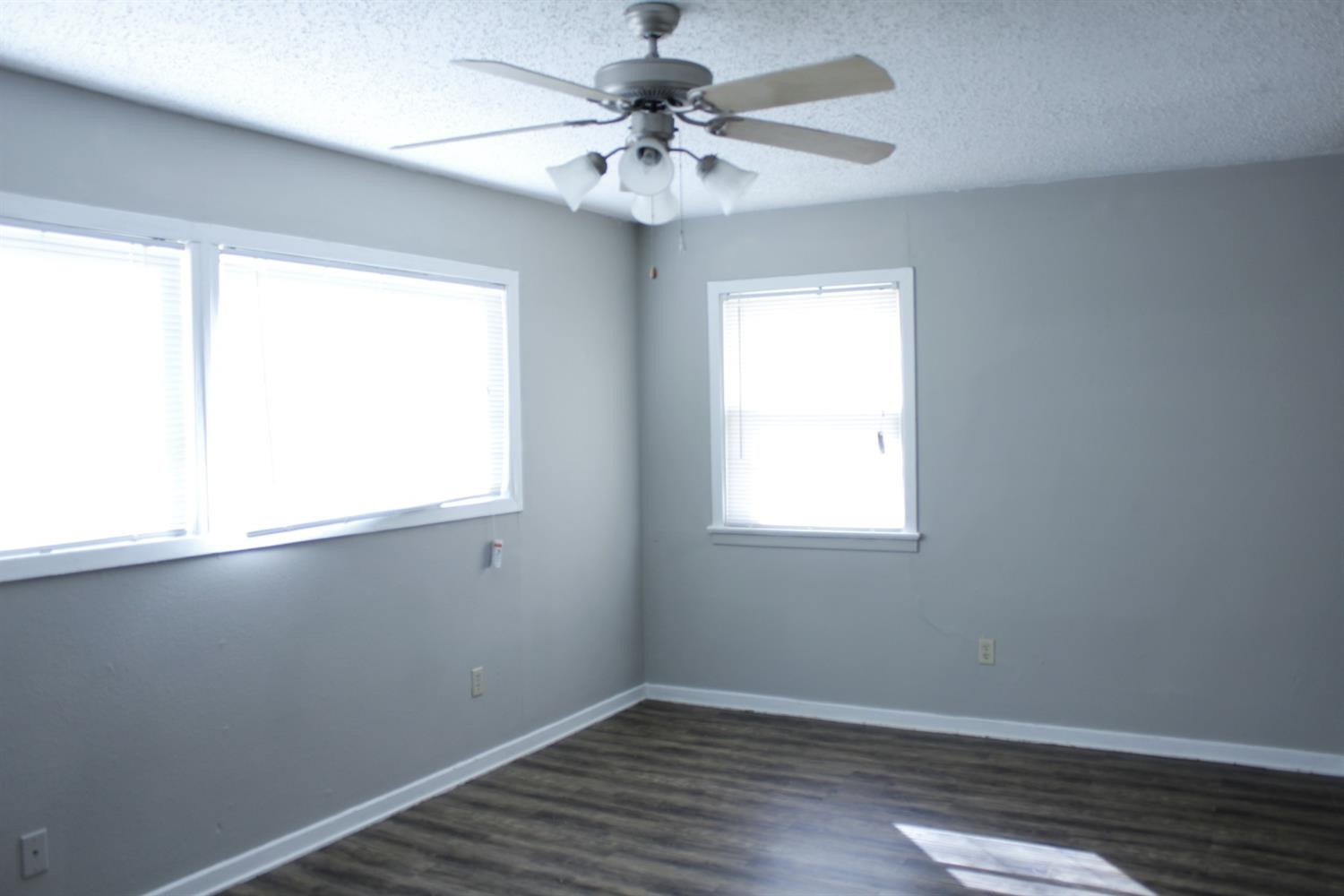4424 36th Street, Unit A Lubbock, TX 79414 - Photo 3 of 6 wooden floor in an empty room with a window