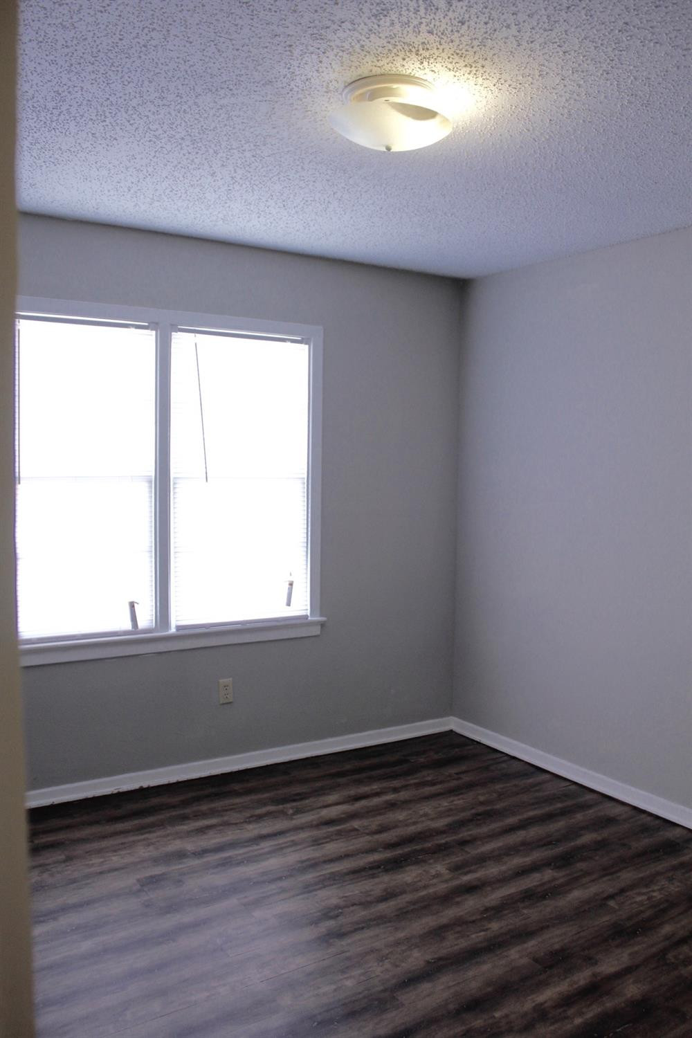 4424 36th Street, Unit A Lubbock, TX 79414 - Photo 5 of 6 an empty room with wooden floor and windows