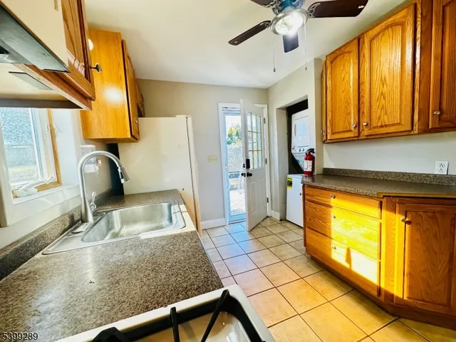 a kitchen with stainless steel appliances granite countertop a refrigerator a sink a stove top oven and cabinets