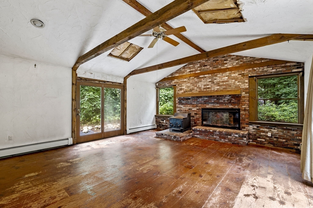 20 Main Street Boxford, MA 01921 - Photo 23 of 40 a view of an empty room with furniture a fireplace and wooden floor