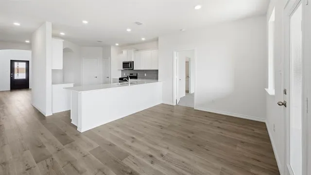 a view of a kitchen with wooden floor and a ceiling fan