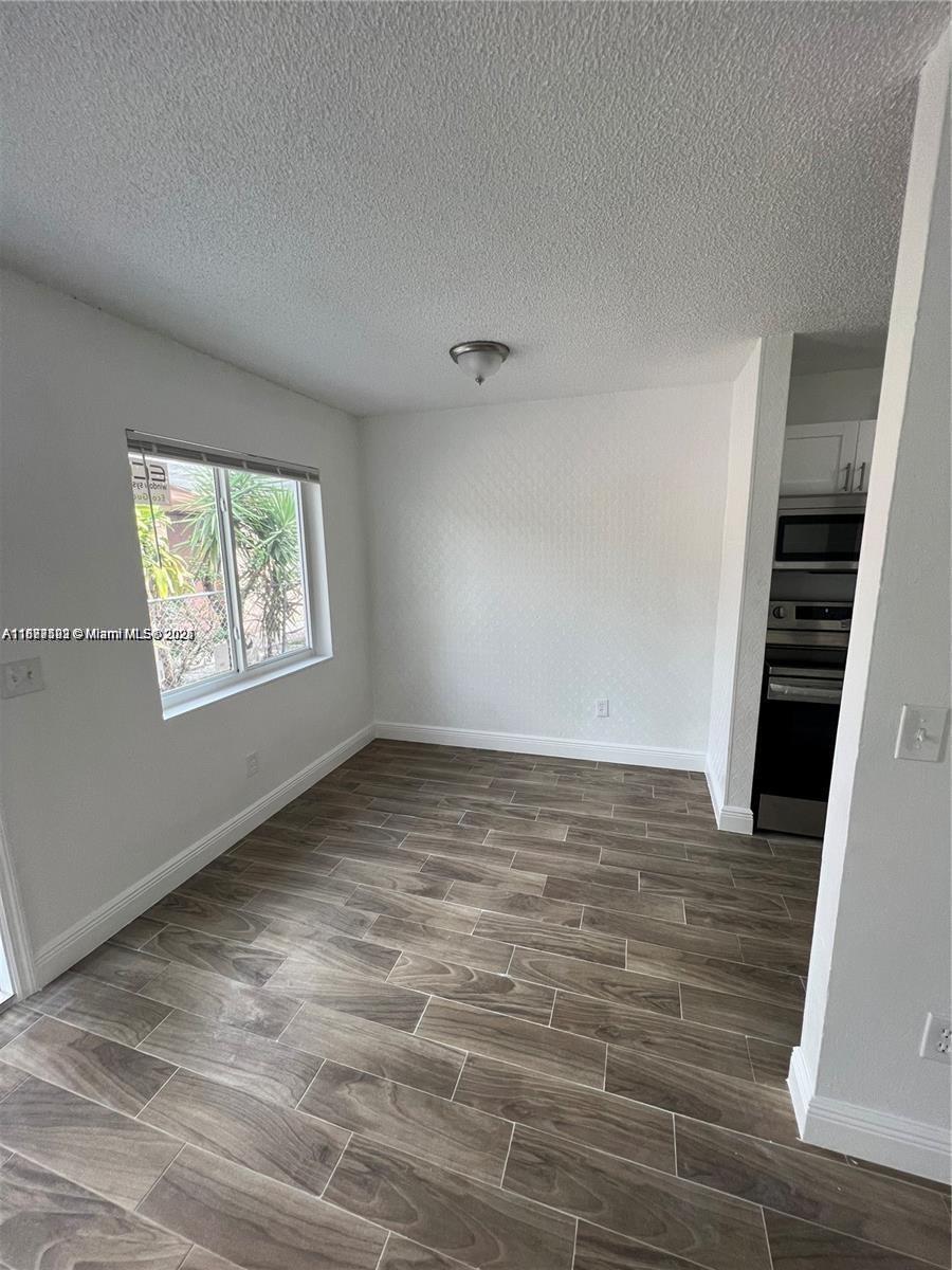 840 Southwest 6th Court, Unit C Pompano Beach, FL 33060 - Photo 4 of 6 wooden floor in an empty room with a window