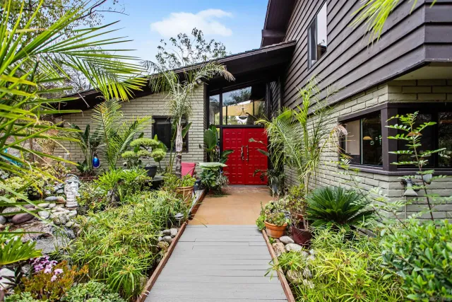 a vase of flowers sitting in front of a house