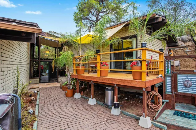 a view of a chairs and table in the patio in front of a house