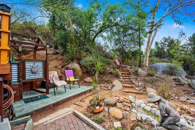 a view of a small house with yard and furniture