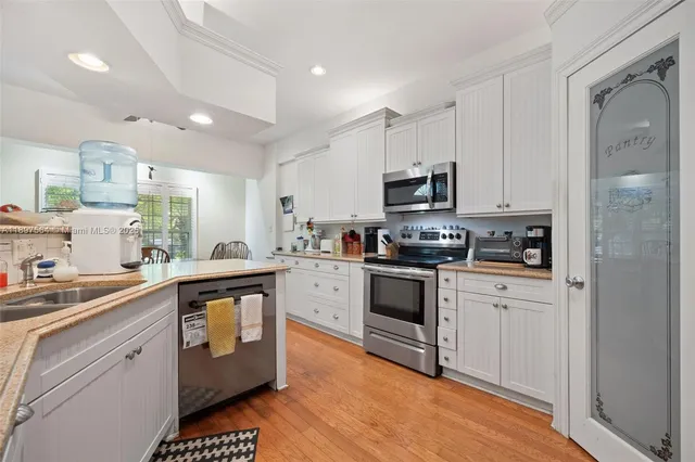 a kitchen with granite countertop a sink stainless steel appliances and cabinets