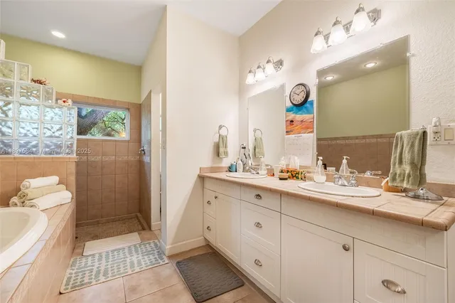 a bathroom with a double vanity sink a mirror and shower