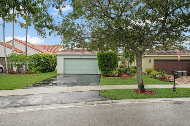 a front view of a house with a yard and a garage