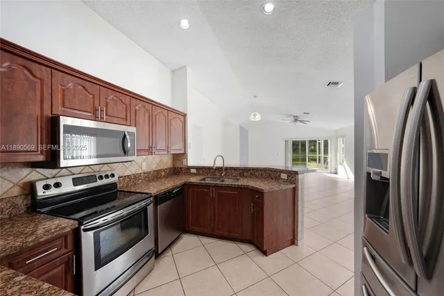 a kitchen with stainless steel appliances granite countertop a stove refrigerator and microwave