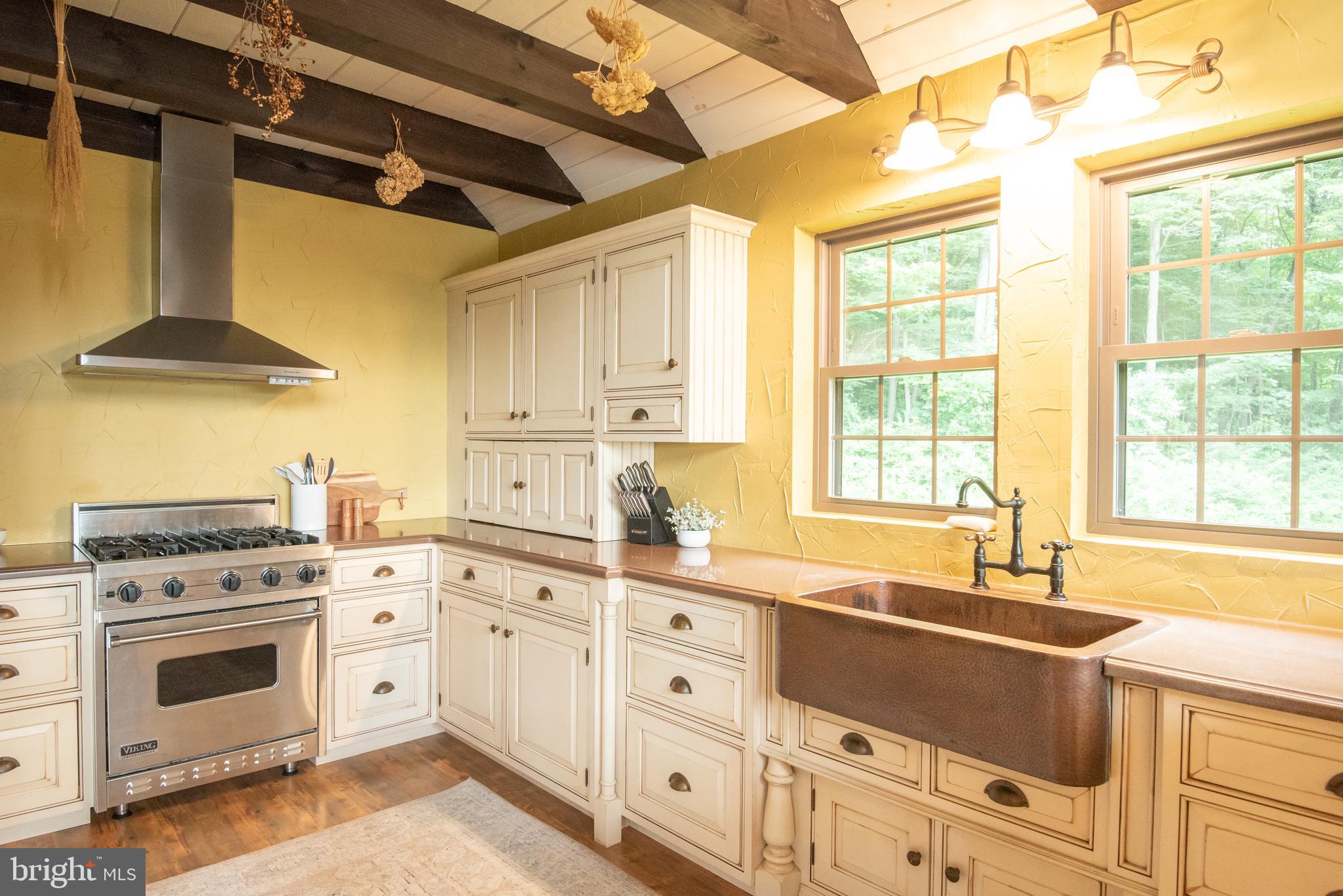 300 Beegle Road Everett, PA 15537 - Photo 14 of 114 a kitchen with granite countertop a stove a sink dishwasher and white cabinets with wooden floor