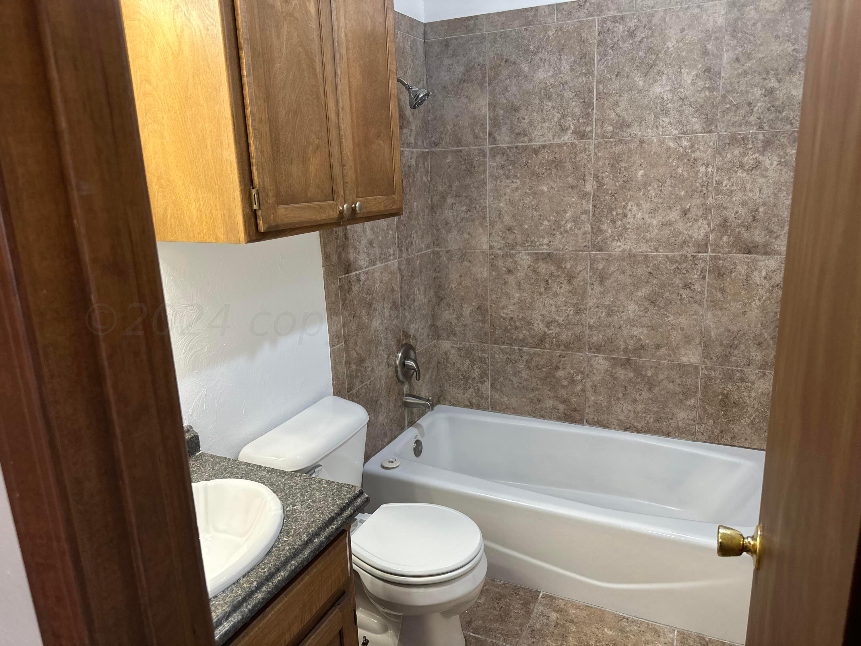 4225 Jamie Trail Amarillo, TX 79110 - Photo 13 of 15 a white toilet sitting next to a bathtub