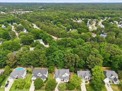 an aerial view of residential houses with outdoor space and trees