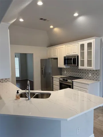a kitchen with stainless steel appliances granite countertop a sink and a stove