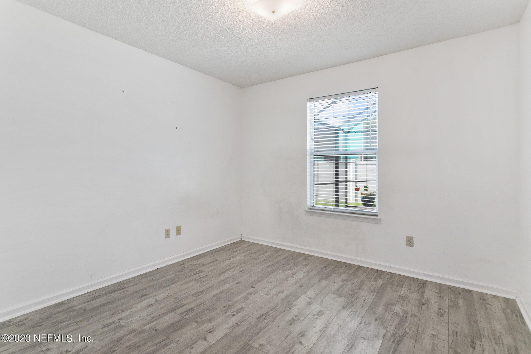 6650 Ricker Road Jacksonville, FL 32244 - Photo 17 of 41 an empty room with wooden floor and windows
