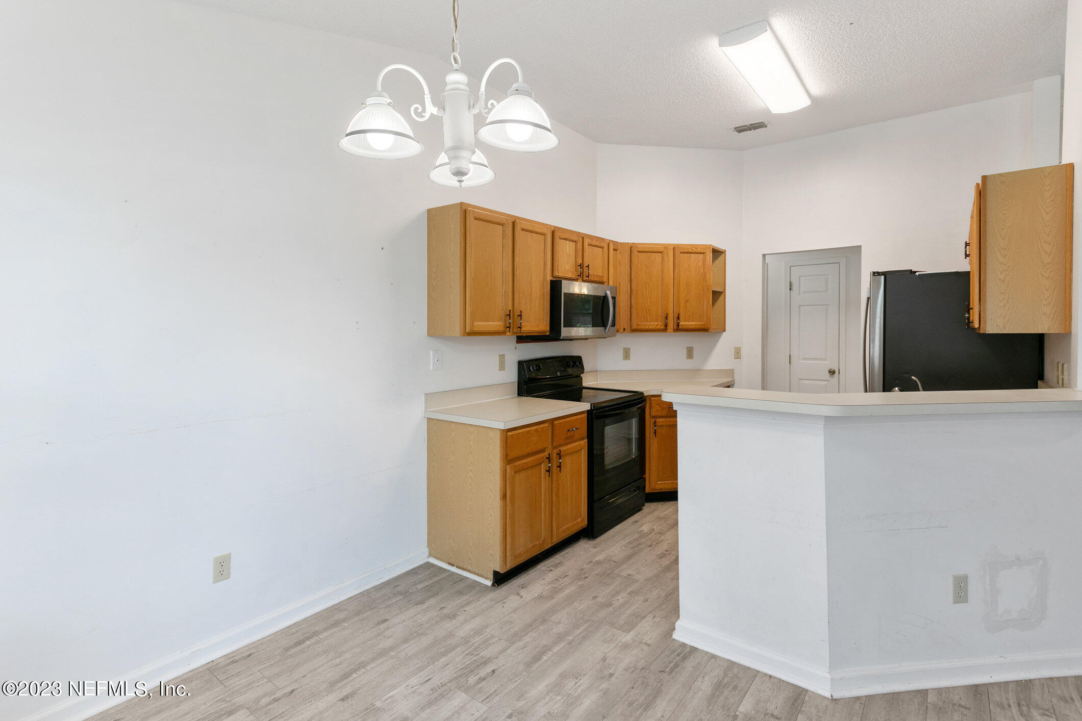 6650 Ricker Road Jacksonville, FL 32244 - Photo 23 of 41 a kitchen with stainless steel appliances granite countertop a sink a stove top oven a chimney wooden floor and cabinets