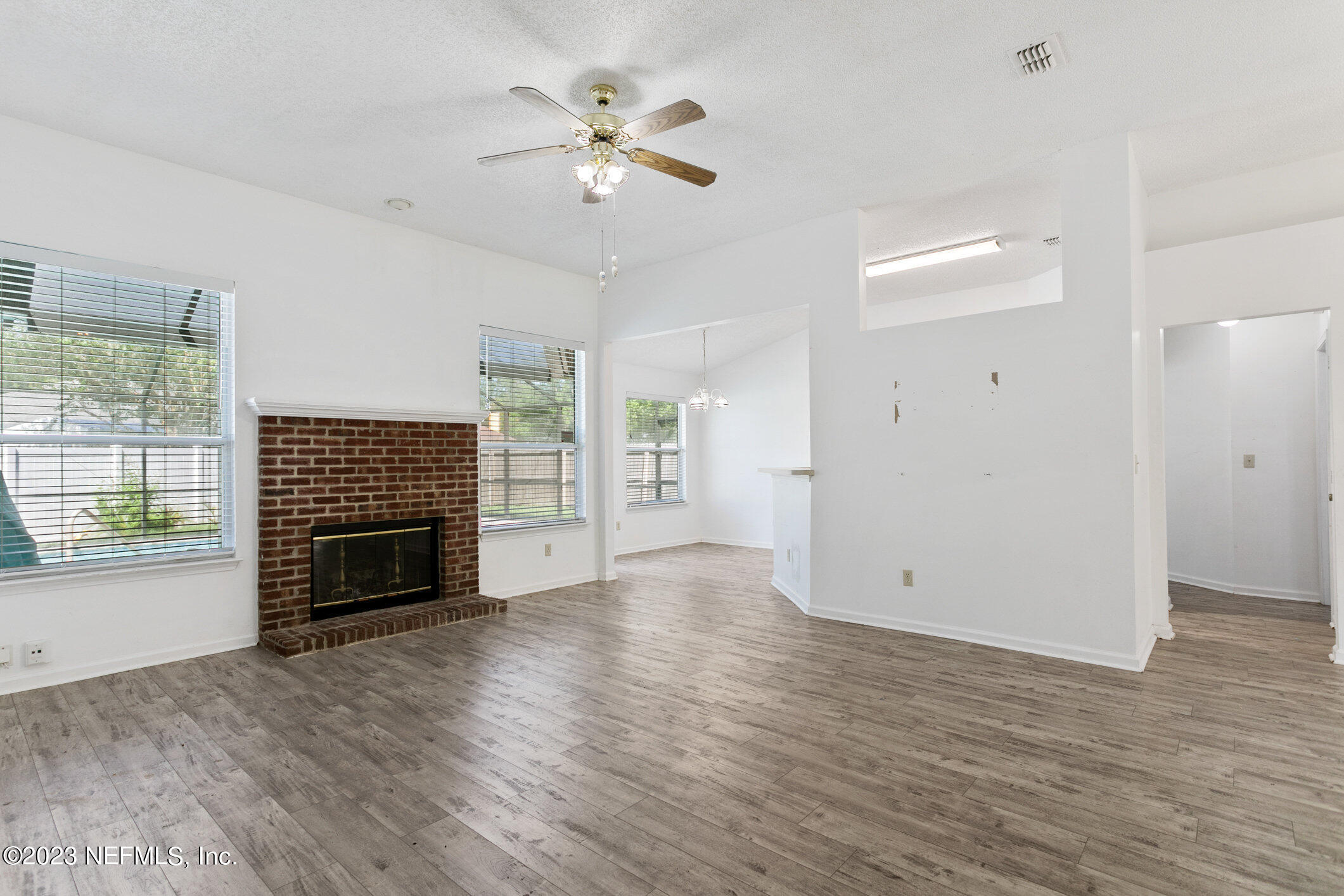 6650 Ricker Road Jacksonville, FL 32244 - Photo 10 of 41 an empty room with windows fireplace and wooden floor