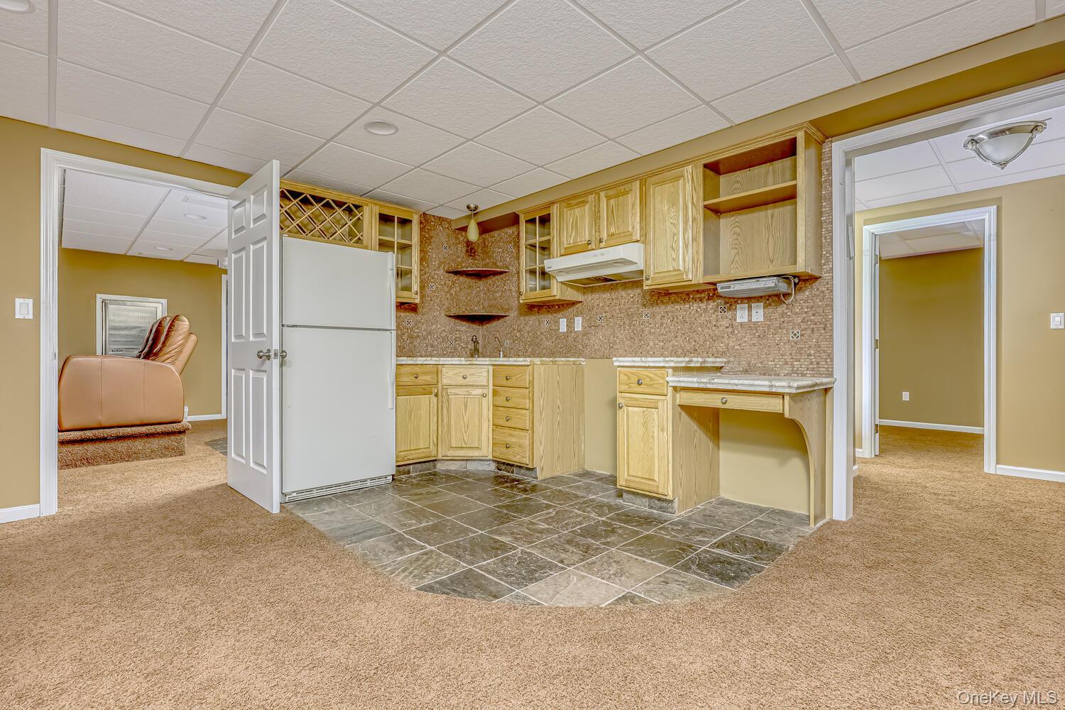 22 Golden Road Suffern, NY 10901 - Photo 37 of 41 Kitchen featuring a drop ceiling, light carpet, freestanding refrigerator, light brown cabinetry, and light countertops
