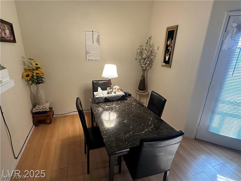 1830 North Pecos Road, Unit 230 Las Vegas, NV 89115 - Photo 7 of 16 Hardwood floors complement the dining area, featuring an exterior door for easy access.
