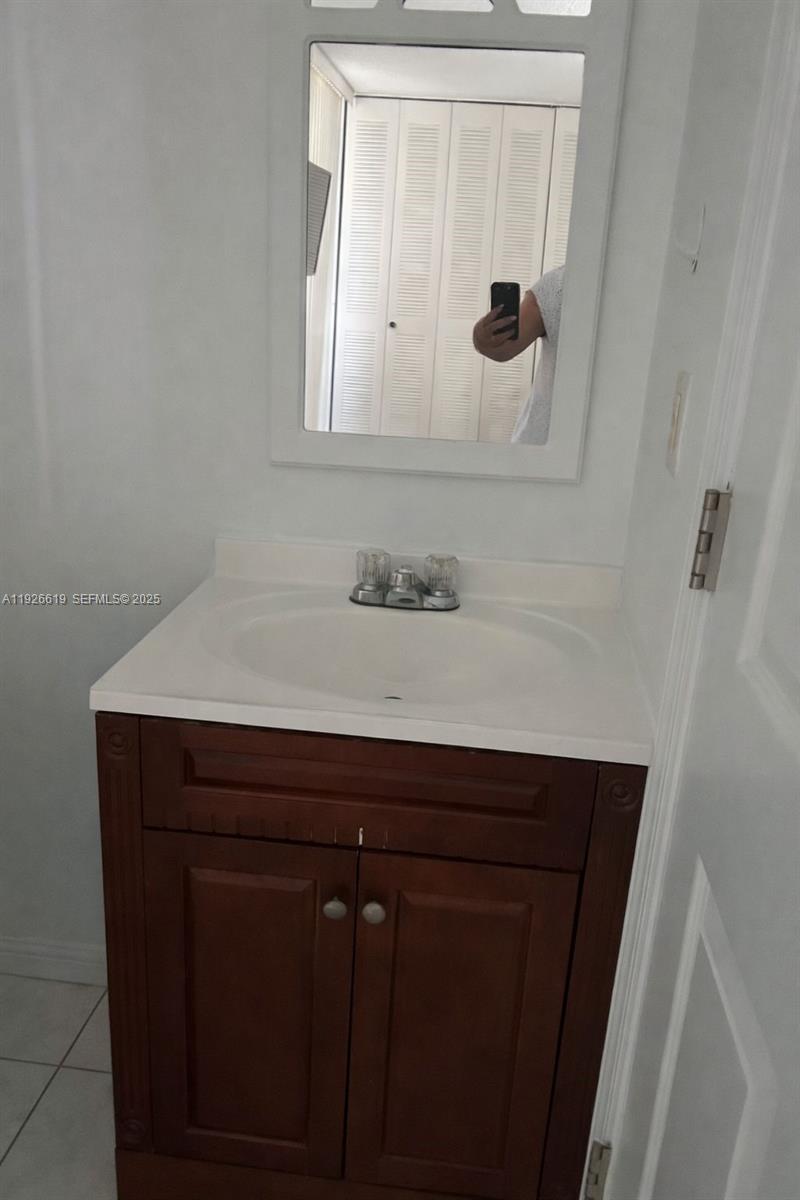 19701 Southwest 114th Avenue, Unit 26914 Miami, FL 33157 - Photo 5 of 7 a bathroom with a sink and a mirror