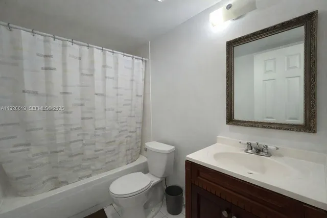 a bathroom with a granite countertop sink a toilet and a mirror