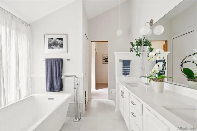 a spacious en suite bathroom with a double vanity sink and a bathtub