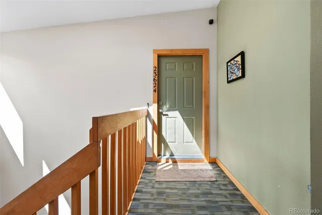 a view of a hallway with wooden floor and stairs