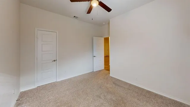 an empty room with a window and a ceiling fan
