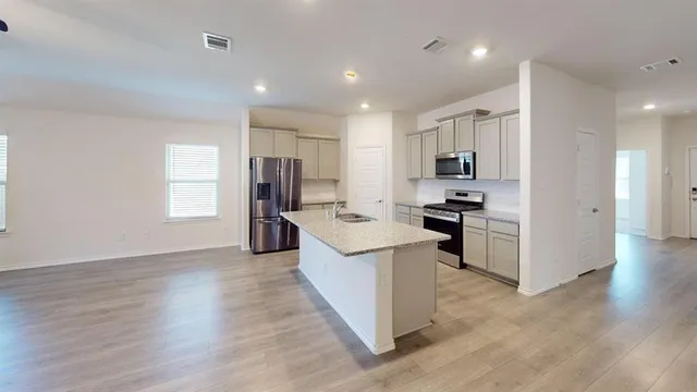 a kitchen with a refrigerator and a stove top oven