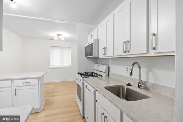 a kitchen with stainless steel appliances granite countertop a sink a stove and cabinets