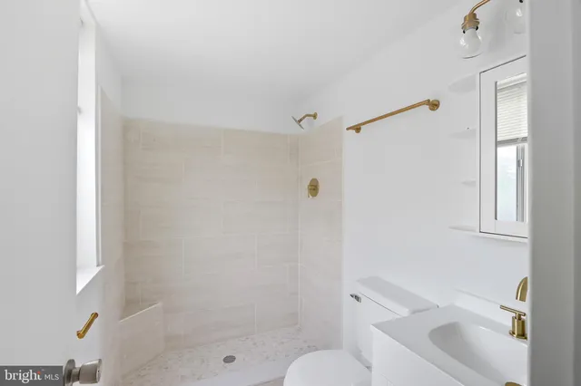 a bathroom with a bathtub shower sink vanity and toilet