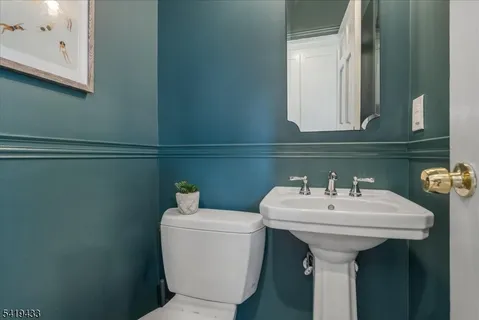 a bathroom with a sink a mirror and toilet