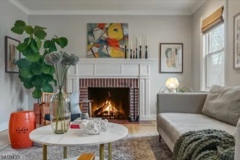 a living room with furniture a fireplace and wall paintings