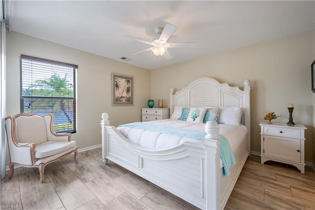 367 Dover Place, Unit 1002 Naples, FL 34104 - Photo 12 of 31 a bed room with a bed and a chair
