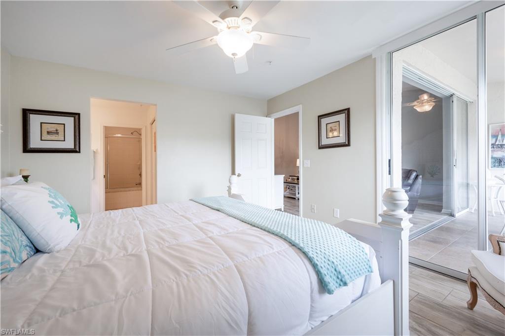 367 Dover Place, Unit 1002 Naples, FL 34104 - Photo 13 of 31 a bedroom with a bed and a chandelier